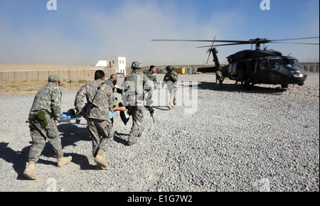 Aviateurs et soldats des États-Unis avec l'Équipe de reconstruction provinciale de Zaboul charger un patient afghans blessés dans un UH-60 Black Hawk h Banque D'Images