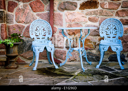 Les meubles extérieurs en métal peint en bleu sur le patio en pierre Banque D'Images