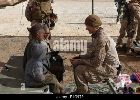 Corps des Marines des États-Unis Le Cpl. Catherine Brousard parle avec des enfants afghans à l'hygiène lors d'une mission médicale de village i Banque D'Images