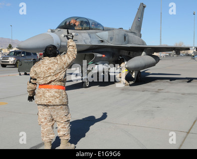 Un United Arab Emirates Air Force (UAEAF) préposé à la main donne des signaux à un UAEAF F-16 Falcon désert après une mission pilote duri Banque D'Images