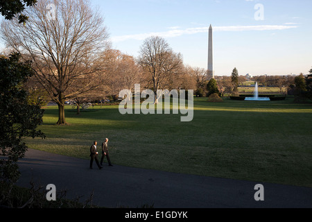 Le président des promenades avec le chef de cabinet Denis McDonough le long de l'Allée du sud de la Maison Blanche, le 1 avril 2014 à Washington, D.C. Banque D'Images