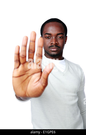 Jeune homme africain montrant un panneau d'arrêt à main sur fond blanc Banque D'Images