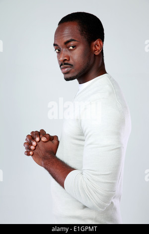 Vue latérale d'un portrait de l'Afrique de l'homme graves sur fond gris Banque D'Images