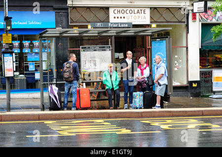 Nottingham,04 juin 2014.Unseasonal est placé pour continuer par temps de forte pluie la majeure partie de la journée.les vacanciers à la sombre sous abri bus,Nottingham. Banque D'Images