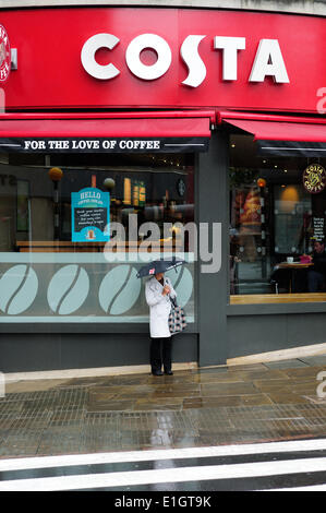 Nottingham, Royaume-Uni. 04 Juin, 2014. Météo Unseasonal est configuré pour continuer avec heavy rain, la plus grande partie de la journée.femme prend logement en dehors Coasta café, Nottingham. Crédit : Ian Francis/Alamy Live News Banque D'Images