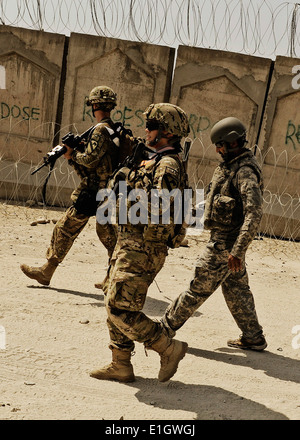 Un élément de sécurité escorts U.S. Air Force Le Capitaine Deana Porter, premier plan, un assistant du médecin attaché à Laghman Provincia Banque D'Images