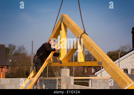 L bâtiment maison, fermes de toit en cours de mise en place par grue, truss mise à niveau avec le niveau à bulle Banque D'Images
