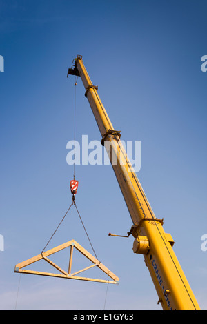 L bâtiment maison, charpente bois faites en usine en cours de mise en place sur le toit par grue Banque D'Images