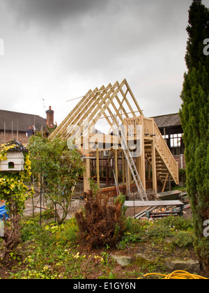 Bâtiment maison auto, le montage de la structure en chêne vert, toit fixation espars avec pluie nuages gris passage Banque D'Images