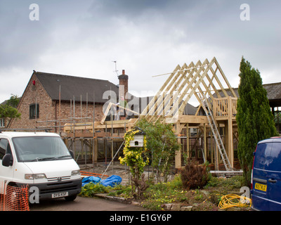 Bâtiment maison auto, le montage de la structure en chêne vert, toit fixation espars avec pluie nuages gris passage Banque D'Images