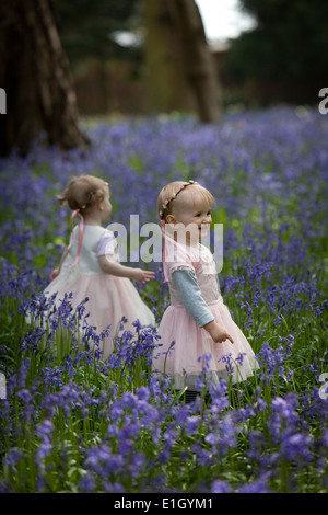 Deux jeunes enfants dans un bois plein de jacinthes en Angleterre au printemps Banque D'Images