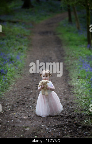 Petite fille qui marche le long d'un chemin forestiers au printemps. Banque D'Images