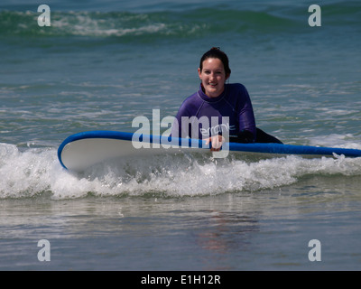 Jeune femme apprendre à surfer, Newquay, Cornwall, UK Banque D'Images