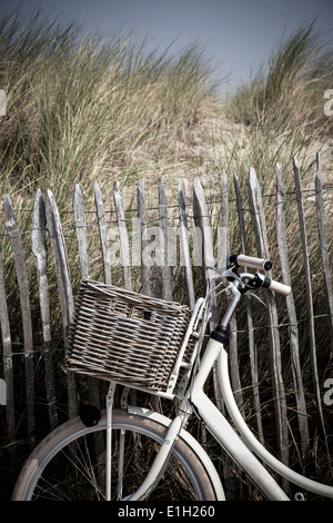 Close up of vélo contre une clôture, de dunes de sable Vollendam, Pays-Bas Banque D'Images