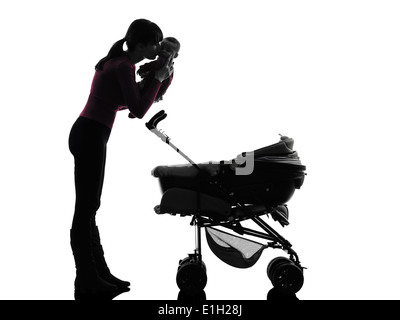 Une femme prams holding baby kissing silhouette sur fond blanc Banque D'Images