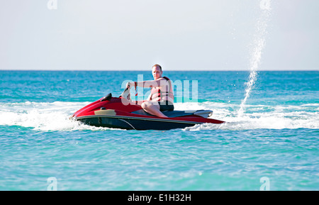 Jeune homme caribbic croisière sur la mer sur un jet ski Banque D'Images