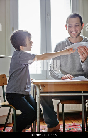 Père holding paper plane pour fils Banque D'Images