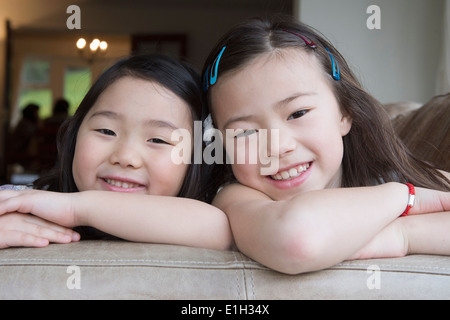 Portrait de deux jeunes filles s'appuyant sur canapé Banque D'Images