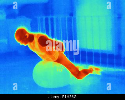 Image thermique de jeune homme de l'entraînement des athlètes avec boule d'exercice. L'image montre la chaleur produite par les muscles Banque D'Images