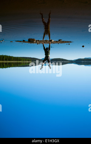 Man doing handstand au lac McCulloch le long du sentier KVR, hauts plateaux de l'Okanagan, Colombie-Britannique, Canada Banque D'Images