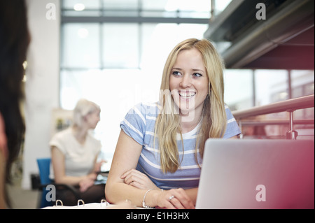 Young woman using laptop in library Banque D'Images