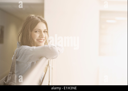 Young woman leaning on railing, portrait Banque D'Images