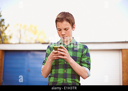 Boy using cell phone Banque D'Images