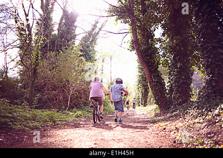 Garçon sur le vélo avec un ami sur un chemin forestier Banque D'Images