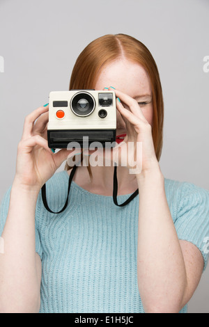 Jeune femme avec un appareil polaroid Banque D'Images