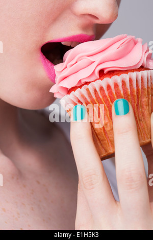 Portrait of young woman holding cupcake Banque D'Images