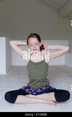 Portrait de fillette de douze ans assis sur le plancher du grenier Banque D'Images