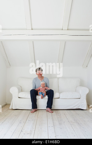 Portrait of mature père avec sa petite fille sur canapé Banque D'Images