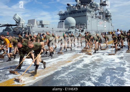 Marins et marines avec la 11e Marine Expeditionary Unit (MEU) 11e, frotter le pont de vol de l'assaut amphibie sh Banque D'Images