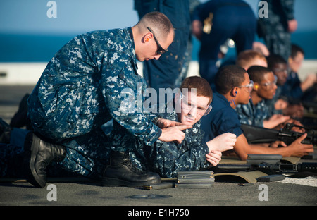 Le chef de l'US Navy Gunners Mate Frank Smith, spécialiste de la logistique, indique à gauche 2e classe David Elliot, deuxième à gauche, au cours de Banque D'Images