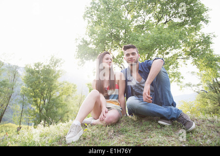 Portrait of young couple sitting on grass, Piemonte, Italie Banque D'Images