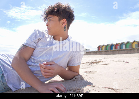 Portrait of young man lying on beach Banque D'Images