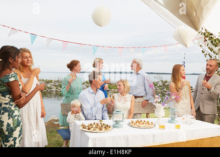 Couple faire un toast avec des amis à réception de mariage Banque D'Images