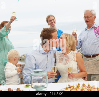 Couple s'embrasser et faire un toast avec un groupe d'amis, Banque D'Images