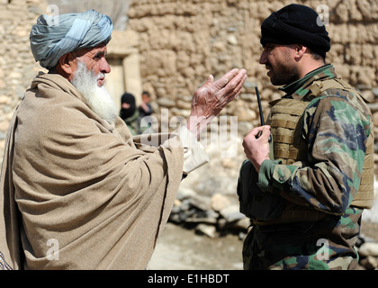 Une armée nationale afghane (ANA) commando, droite, effectue un leader clé engagement avec un ancien du village afghan lors d'une mission je Banque D'Images