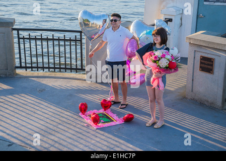 Couple annoncer publiquement leur amour avec des ballons roses et des coeurs Banque D'Images