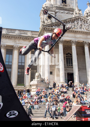 Un scooter rider effectue une cascade aérienne en face de la Portsmouth Guildhall au cours de la rue de Portsmouth en 2014 Banque D'Images