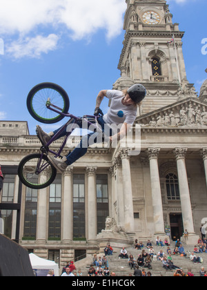 Un rider BMX effectue une cascade aérienne devant la foule rassemblée sur la Portsmouth Guildhall, étapes au cours de la rue Portsmouth Banque D'Images