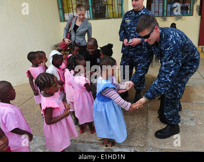 Musicien de la marine américaine de la classe 3ème Patrick Pedlar, membre de l'U.S. Naval Forces Europe Band band Topside, danse avec un enfant Banque D'Images