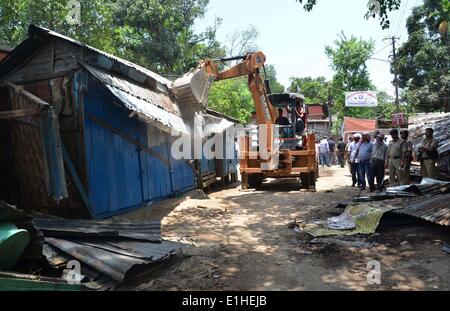 Le Nagaland, l'état indien du Nagaland. 4 juin, 2014. Le personnel de sécurité et les spectateurs regardent un bulldozer démolit une construction illégales au cours d'un entraînement d'expulsion menées conjointement par l'Autorité des chemins de fer indiens et Nagaland entrepreneur ferroviaire Union européenne le long de la gare de Jodhpur, au nord est de l'état indien du Nagaland, le 4 juin 2014. © Caisii Mao/Xinhua/Alamy Live News Banque D'Images
