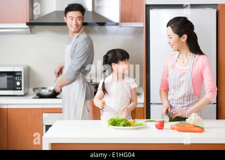 Young family cooking in kitchen Banque D'Images