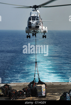 Un hélicoptère Super Puma comme-332 offre de fret vers la cabine de pilotage du navire quai de transport amphibie USS New York (LPD 21) d Banque D'Images