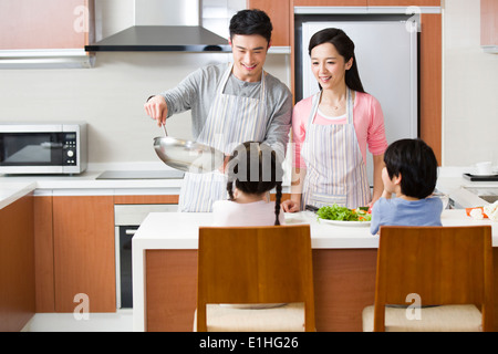 Young family cooking in kitchen Banque D'Images