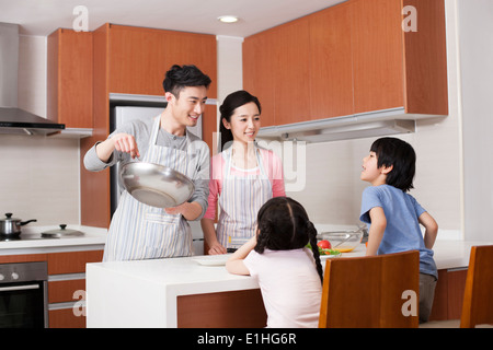 Young family cooking in kitchen Banque D'Images