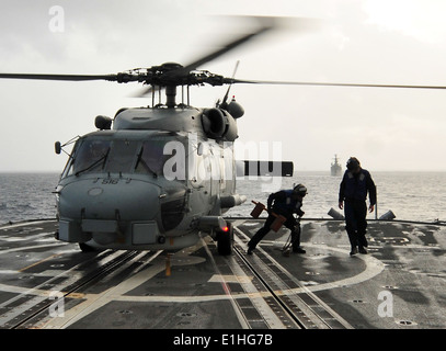 Les marins américains retirer des cales et des chaînes d'un SH-60B Seahawk Hélicoptère Hélicoptère affecté à l'Escadron anti-sous-marin (H Banque D'Images