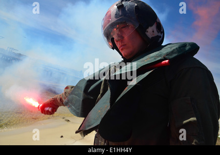 U.S. Navy Ensign Cris Forero, étudiant à l'Institut de formation de survie de la Marine (NSTI), allume une torche de nuit après une journée de l'eau Banque D'Images